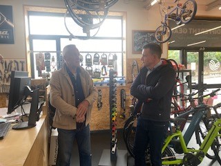 Two men standing talking between bikes and bike racks